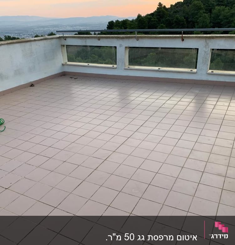 מרפסת מרוצפת עם צינור ירוק ומזגן